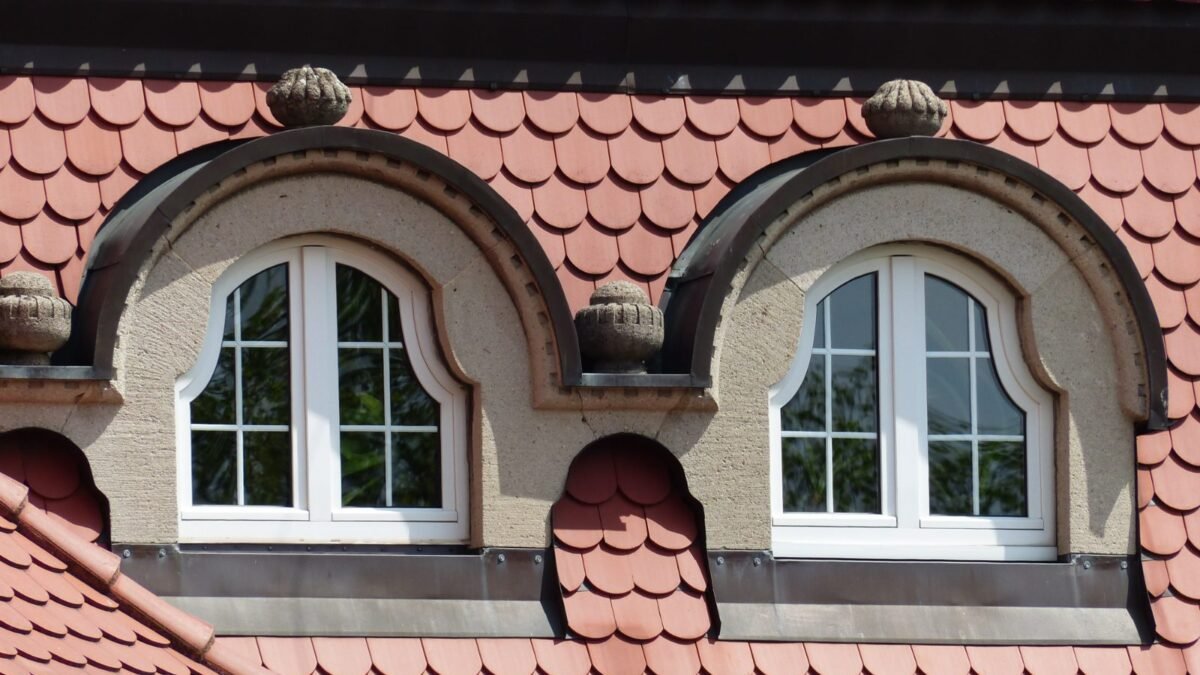 Clay tile roof with arched dormer windows, from our guide to whether insurance covers roof replacement