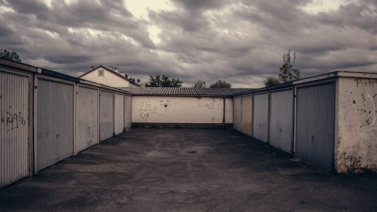 Row of closed garage doors under a stormy sky, from our garage door not opening guide