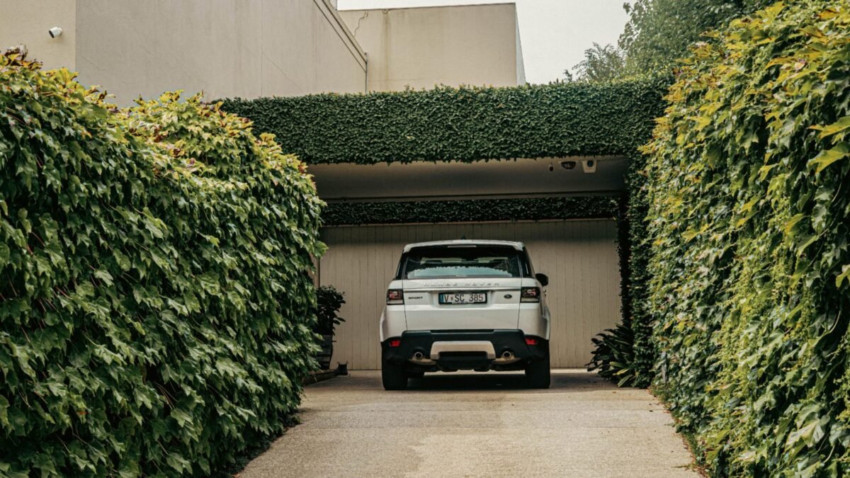 SUV parked on a driveway in front of a garage door, from our garage door off track guide
