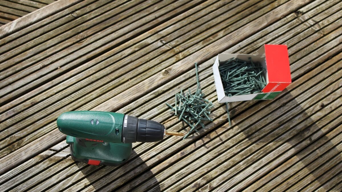 Cordless drill and deck screws on wooden decking boards