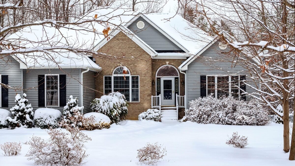 House with gray vinyl siding and a brick front in winter